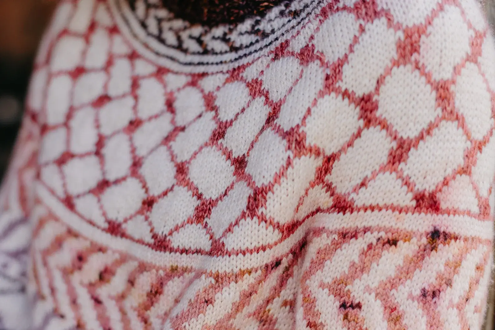 Close-up of the Children of Gaza Sweater showing keffiyeh-inspired colourwork in dusty rose and cream on a soft marled yoke